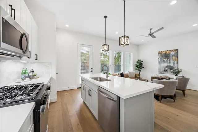 a kitchen with a stove a sink a dining table and chairs