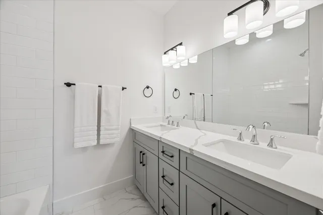 a bath room with a sink vanity tub and shower