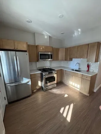 a kitchen with stainless steel appliances wooden floors and wooden cabinets