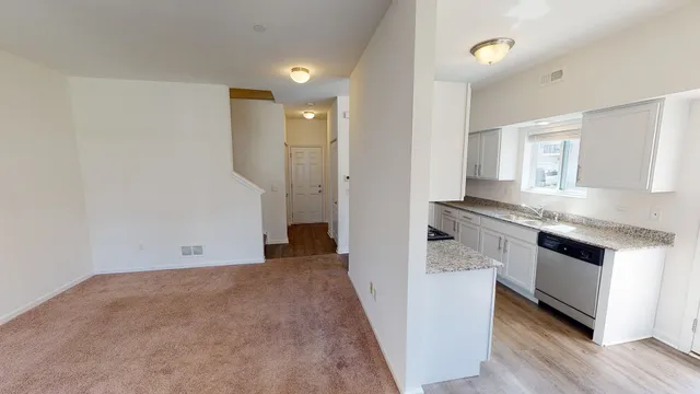 a view of kitchen with granite countertop cabinets appliances and wooden floor