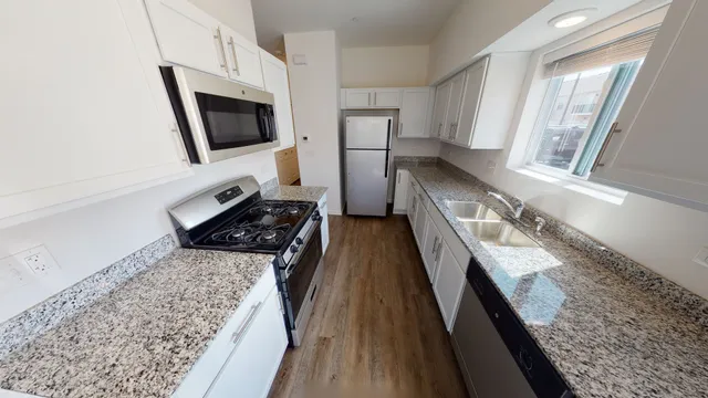 a kitchen with stainless steel appliances granite countertop a sink stove and microwave