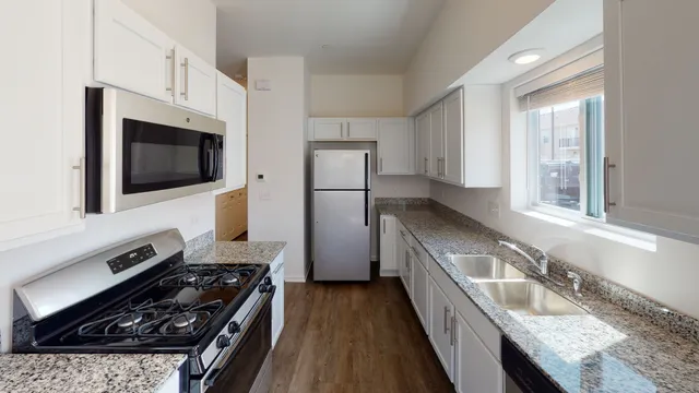 a kitchen with stainless steel appliances granite countertop a sink stove and refrigerator