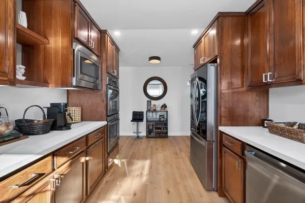 a kitchen with granite countertop a stove a sink dishwasher and cabinets with wooden floor