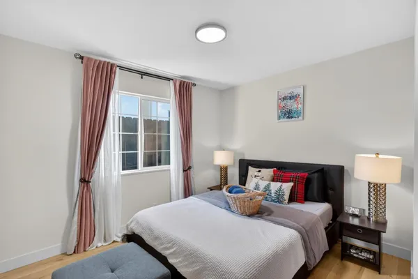 a bedroom with a bed and wooden floor