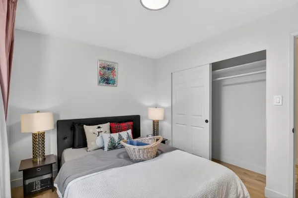 a bedroom with a bed and a lamp on dresser