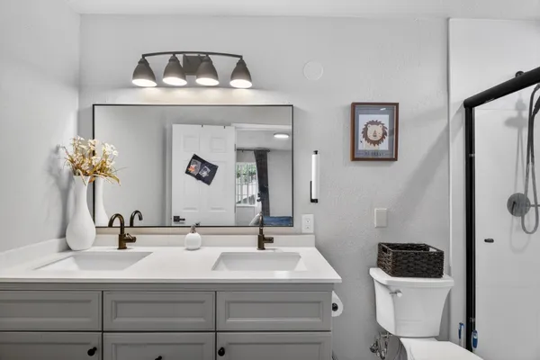 a bathroom with a sink a toilet and a mirror