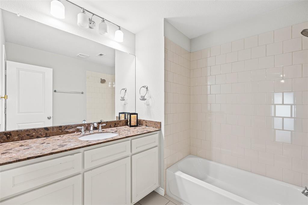 437 Prairie Run Aledo, TX 76008 - Photo 25 of 33 Bathroom featuring a spacious vanity with a brown patterned countertop, white undermount sink, and chrome faucet