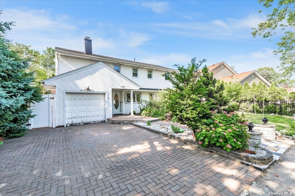 a view of a house with a yard and potted plants