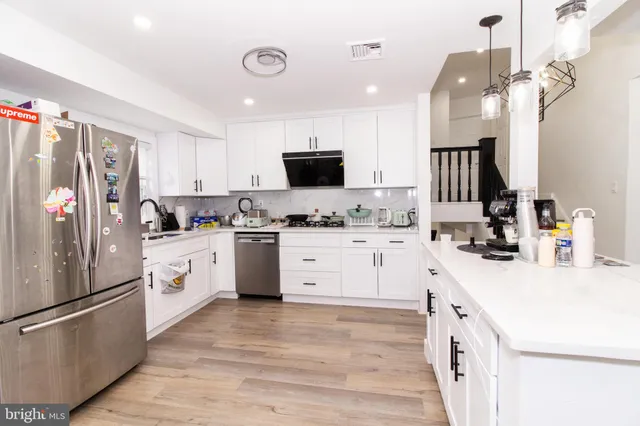 a kitchen with white cabinets and white appliances