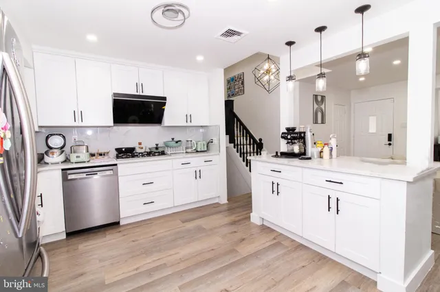 a kitchen with white cabinets and stainless steel appliances