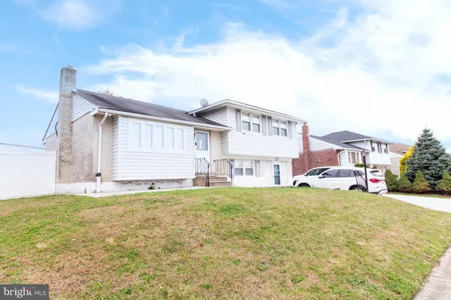 a view of a house with a big yard and large trees