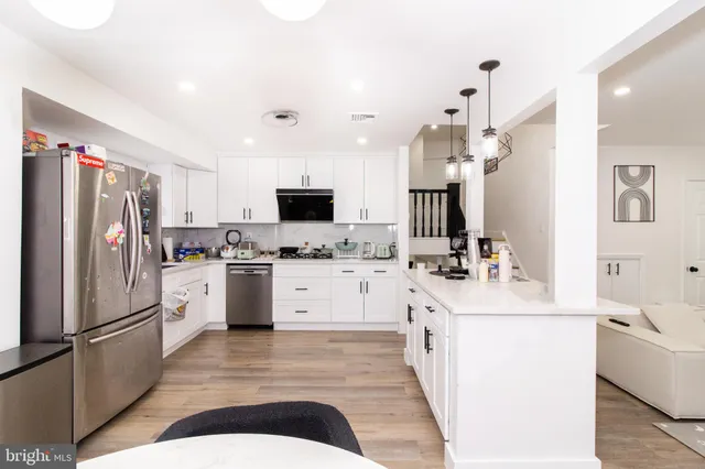 a kitchen with white cabinets and stainless steel appliances
