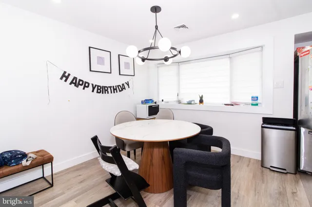 a dining room with furniture a chandelier and wooden floor