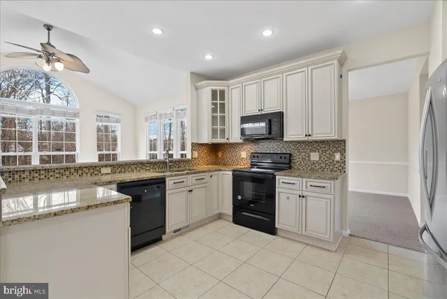 a kitchen with stainless steel appliances granite countertop a stove sink and cabinets