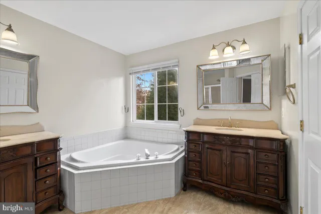 a bathroom with a tub sink and mirror