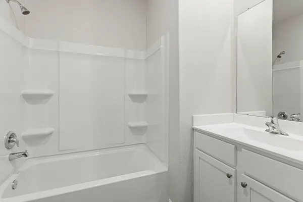 a white bath tub sitting next to a white sink