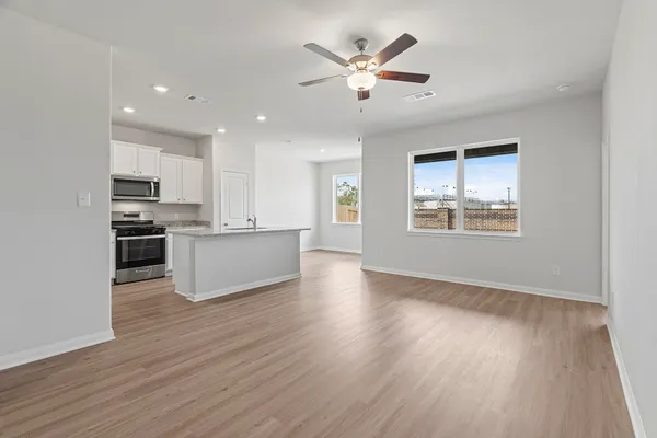 a view of an empty room with kitchen appliances and a window