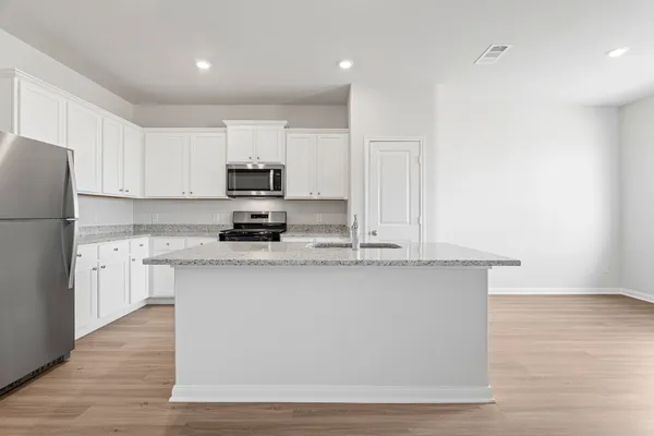 a kitchen with stainless steel appliances granite countertop a stove a sink and a refrigerator