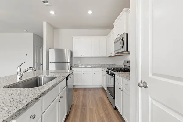 a kitchen with stainless steel appliances granite countertop a sink stove and refrigerator