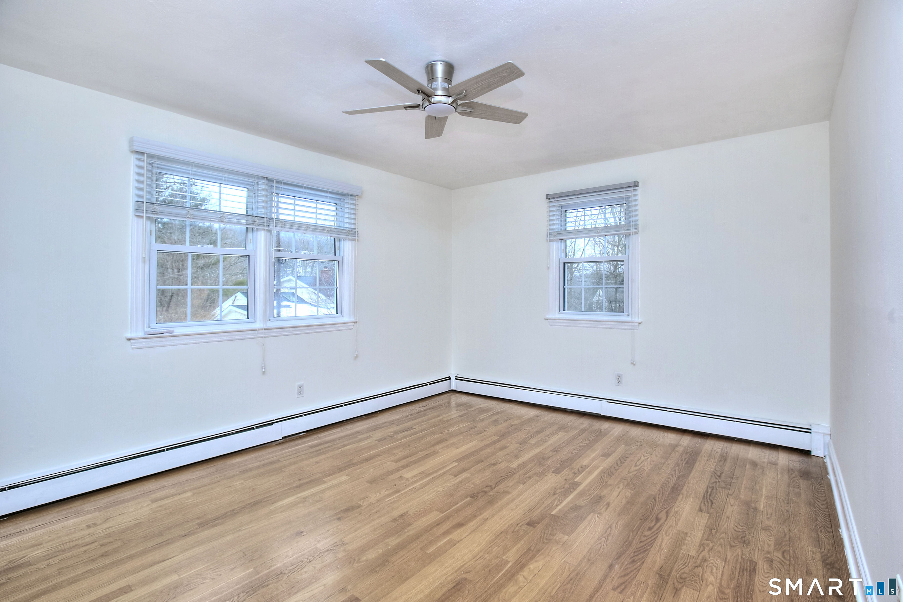 46 Crest Road Ridgefield, CT 06877 - Photo 31 of 41 an empty room with wooden floor ceiling fan and windows