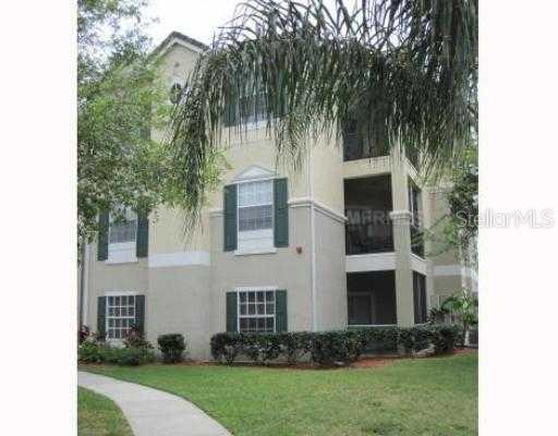 a view of a white house with a yard and potted plants