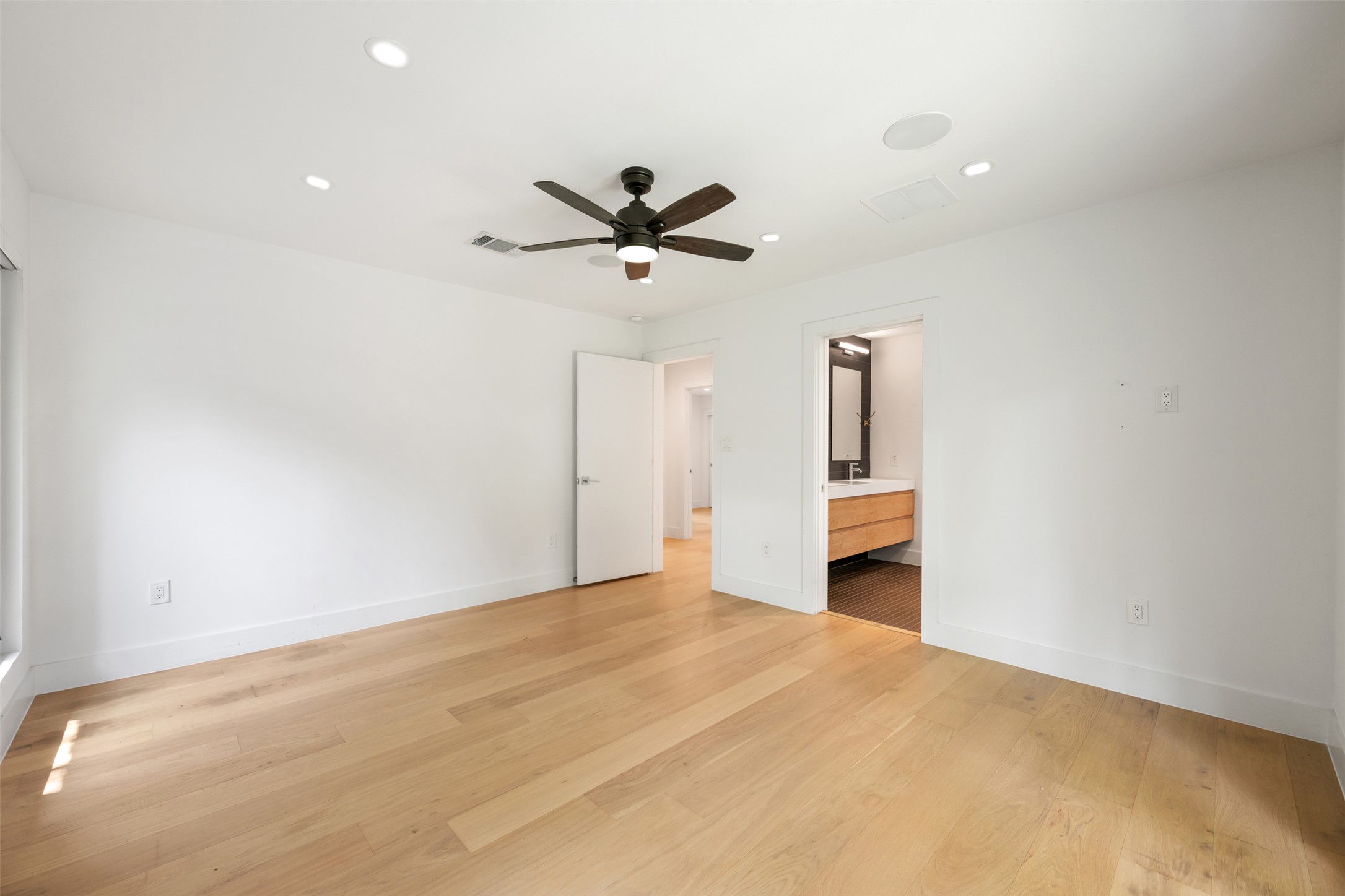 8900 Point W Drive Austin, TX 78759 - Photo 23 of 40 Blonde wood flooring and modern ceiling fixtures define this airy space with a direct bathroom entrance.