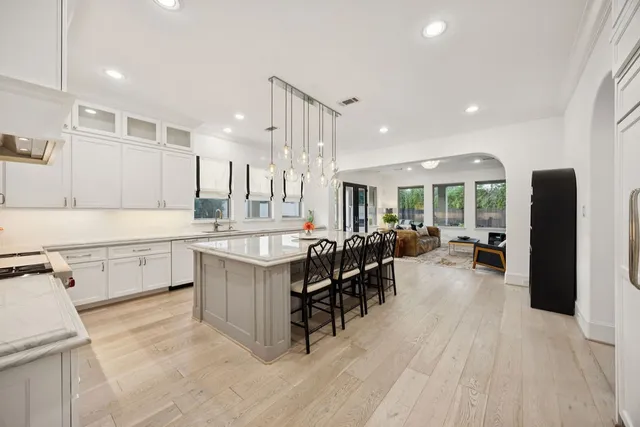 a kitchen with stainless steel appliances granite countertop table chairs sink and cabinets