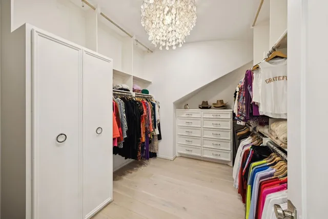 a view of walk in closet with clothes and shoes