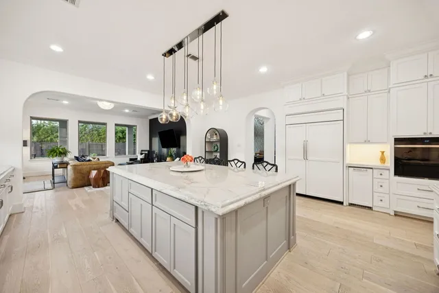 a large white kitchen with a large counter top appliances and cabinets