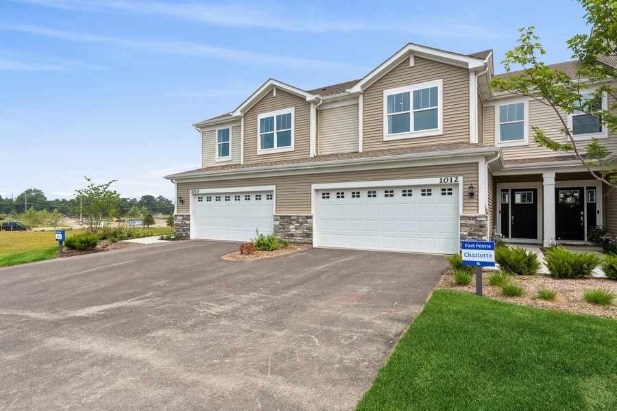 a view of a house with a yard and a garage