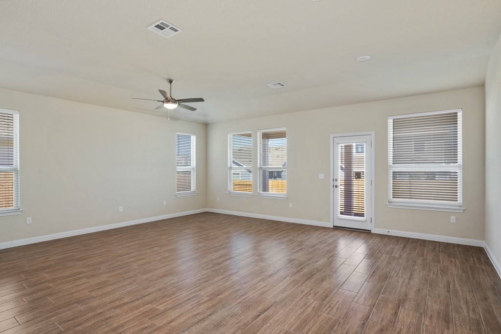 8202 Dampton Lane Austin, TX 78744 - Photo 10 of 25 a view of an empty room with wooden floor and a window