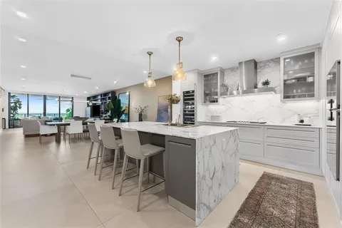a kitchen with stainless steel appliances kitchen island granite countertop a table and chairs in it