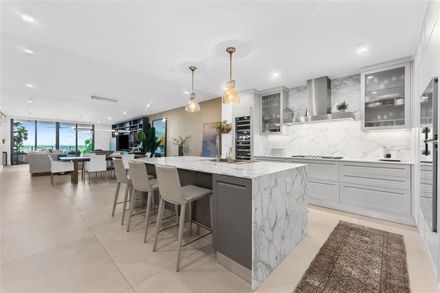 a kitchen with stainless steel appliances kitchen island granite countertop a table and chairs in it