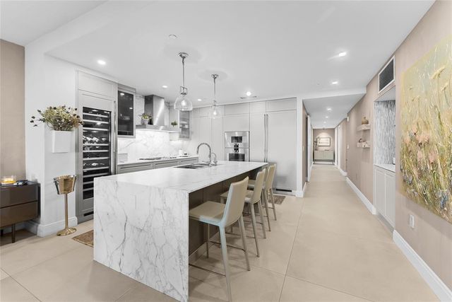 a large kitchen with stainless steel appliances kitchen island granite countertop a sink and cabinets