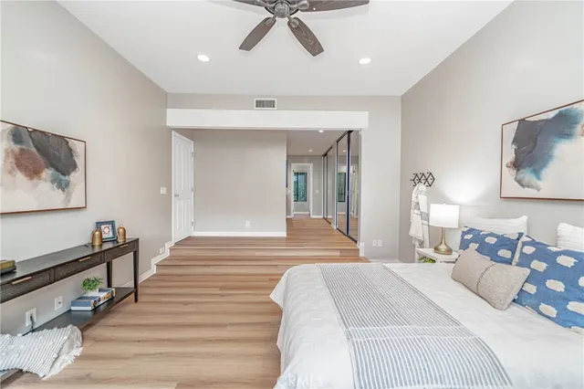 a bedroom with a bed and wooden floor