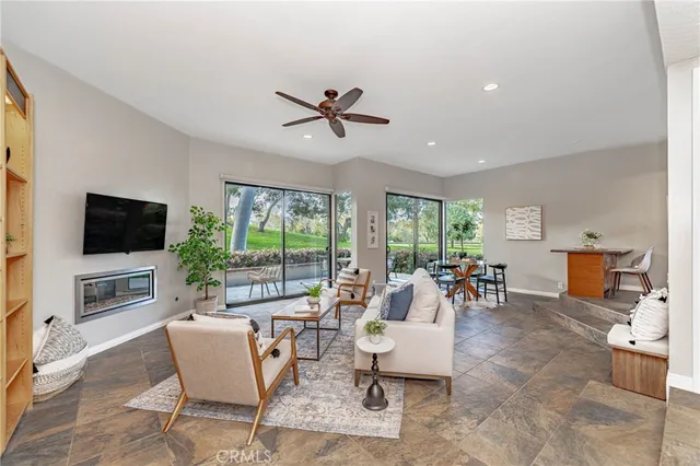 a living room with furniture a flat screen tv and a large window