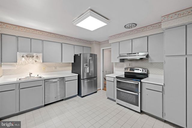 a kitchen with a refrigerator sink and cabinets