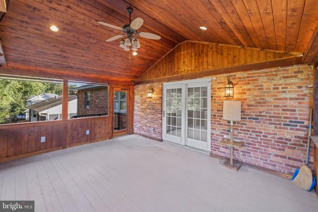 a view of a house with wooden deck front of house