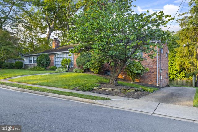 a view of a house with a big yard and large trees