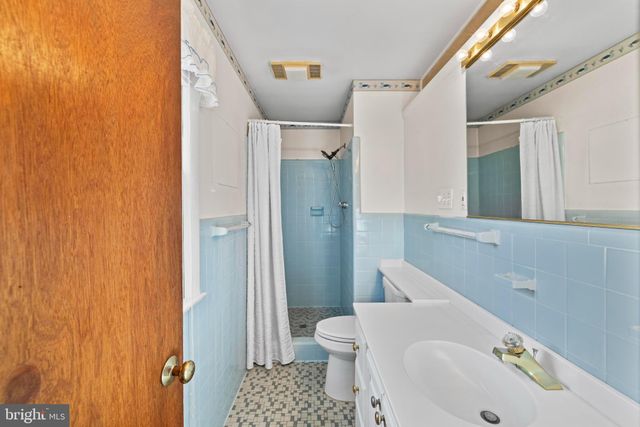 a white toilet sitting next to a bath tub and a shower