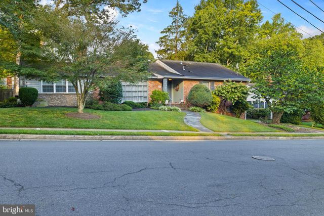 a view of a house with a big yard and large trees