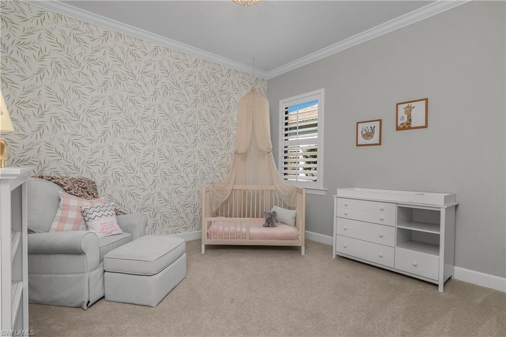 19040 Marquesa Drive Fort Myers, FL 33913 - Photo 24 of 50 Guest bedroom with crown molding, plantation shutters, shelving in closet, and dedicated nearby bath with pocket door that turns this wing into its own private guest suite.