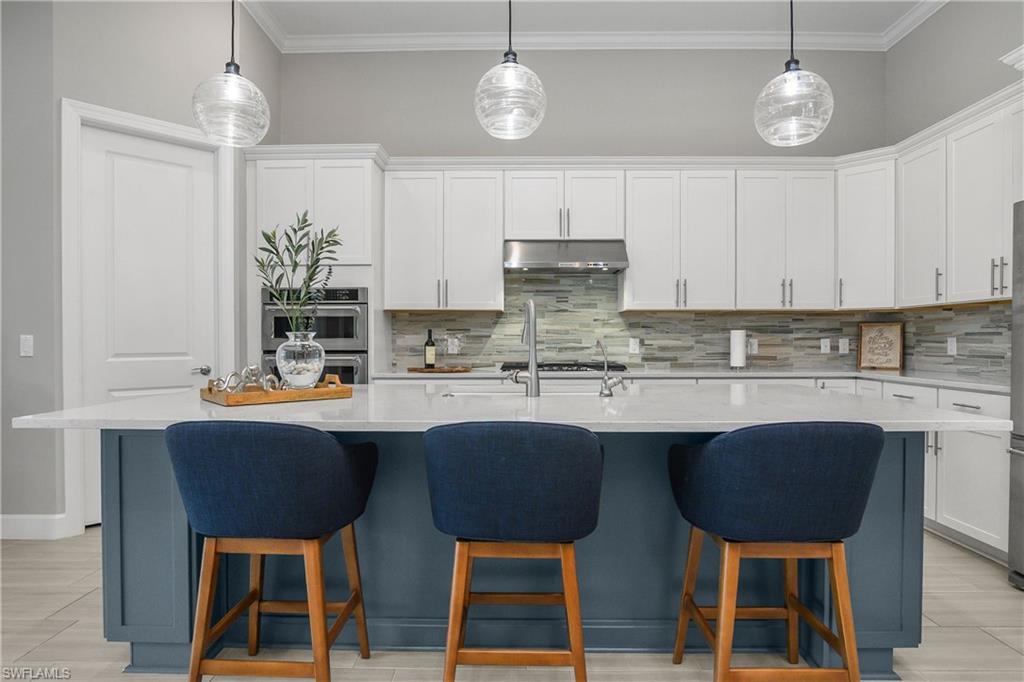 19040 Marquesa Drive Fort Myers, FL 33913 - Photo 6 of 50 The kitchen is perfect for entertaining and includes an oversized island, a spacious walk-in pantry, Kitchen Aid appliances, custom backsplash, designer pendant lighting, and reverse osmosis drinking system.