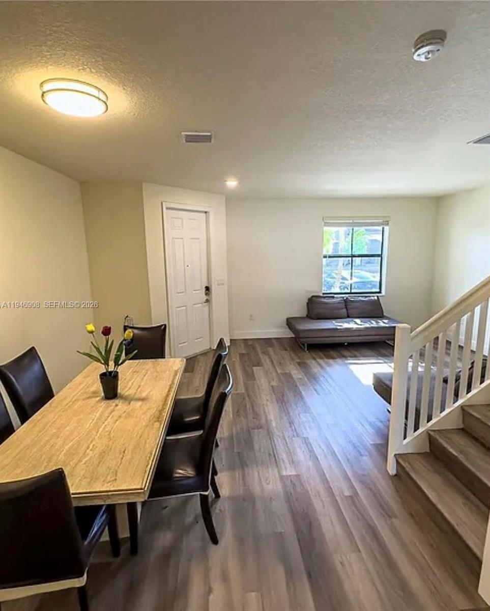 3349 West 105th Terrace, Unit 3349 Hialeah, FL 33018 - Photo 2 of 10 a living room with furniture and a wooden floor