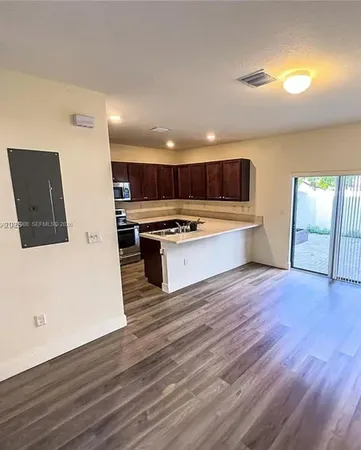 a view of kitchen with wooden floor and electronic appliances
