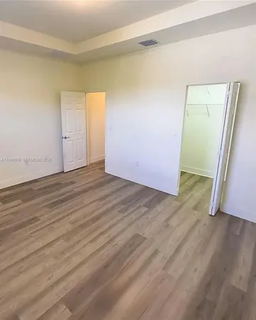 an empty room with wooden floor and closet