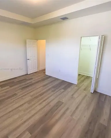 an empty room with wooden floor and closet
