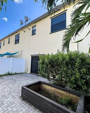 a view of backyard with swimming pool and plants