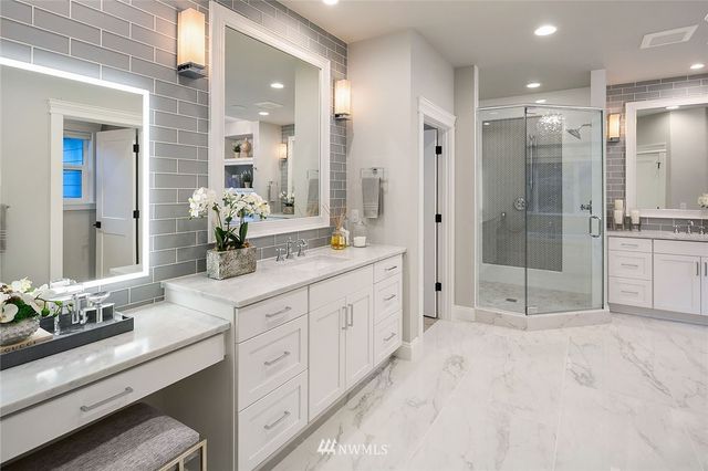 a spacious bathroom with a granite countertop sink mirror and shower