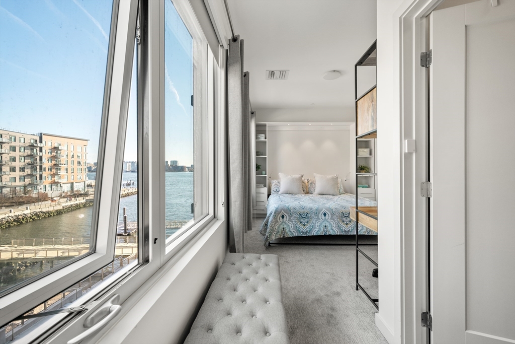 65 Lewis Street, Unit 316 Boston, MA 02128 - Photo 2 of 3 a bedroom with bed and glass door